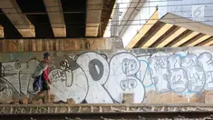 Pencari barang bekas melintasi kolong Flyover Kuningan, Jakarta, Selasa (25/9). Coretan terlihat memenuhi dinding kolong Flyover Kuningan. (Liputan6.com/Immanuel Antonius)