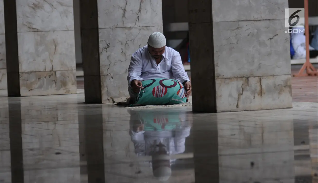 Umat muslim membaca pada hari ke-28 bulan suci Ramadan di pelataran Masjid Istiqlal, Jakarta, Selasa (12/6). Sejumlah umat muslim meningkatkan ibadah mereka dengan itikaf di Masjid Istiqlal jelang berakhirnya Ramadan. (Liputan6.com/Helmi Fithriansyah)