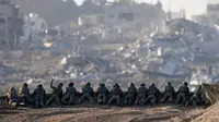 Sebuah foto yang diambil di Israel selatan dekat perbatasan dengan Jalur Gaza pada 11 Desember 2023, menunjukkan tentara Israel berjaga di sebuah bukit yang menghadap ke Gaza utara, di tengah pertempuran yang terus berlanjut antara Israel dan kelompok militan Hamas. (Menahem KAHANA/AFP)