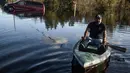 Eric Locklear melintasi banjir menggunakan kano di wilayah Lumberton, Carolina Utara, AS, 12 Oktober 2016. Banjir akibat badai Matthew tersebut merendam kota berpenduduk 21.000 orang itu. (Sean Rayford/Getty Images/AFP)