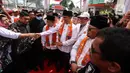 Anies Baswedan menyapa pendukung saat tiba untuk menghadiri deklarasi Capres 2024 di Kantor DPP PKS, Jakarta, Kamis (23/2/2023). Anies mengenakan baju koko putih dipadu celana hitam panjang, dilengkapi dengan peci berwarna senada dan sorban tenun dengan warna oranye yang mendominasi. (Liputan6.com/Johan Tallo)