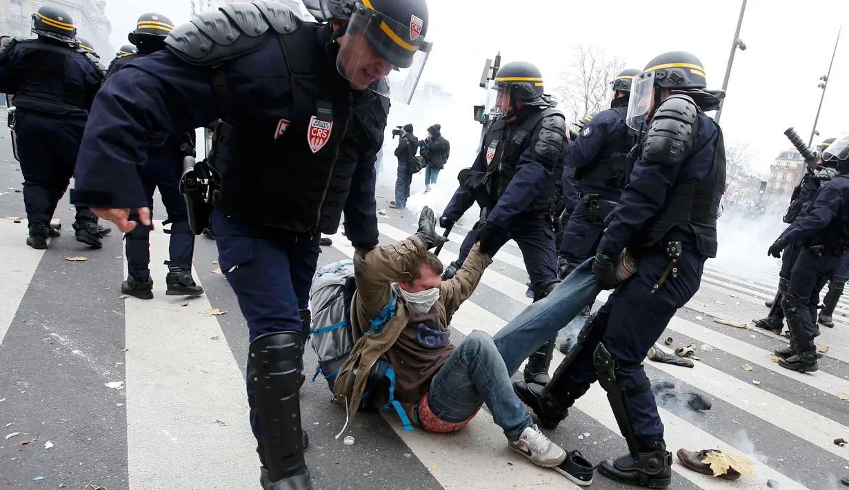 Polisi menangkap salah satu demonstran saat unjuk rasa menjelang Konferensi Perubahan Iklim Dunia 2015 di Place de la Republique Paris, Prancis, Minggu (29/11). Paris melarang semua aksi demonstrasi pasca teror beberapa waktu lalu. (REUTERS/Eric Gaillard)