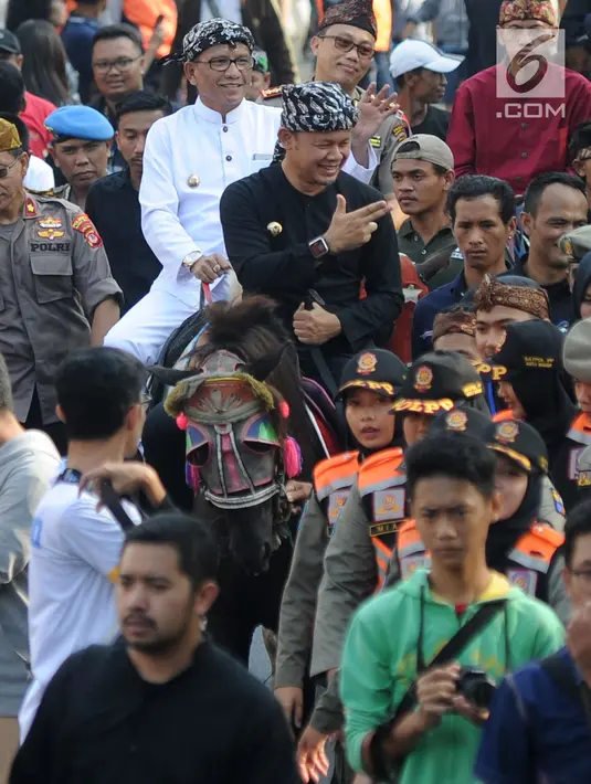 Wali Kota Bogor Bima Arya (depan) bersama Wakil Wali Kota Bogor Usmar Hariman (belakang) naik kuda saat ikut festival budaya Helaran 2018, Bogor, Jawa Barat, Minggu (12/8). Lima ribu peserta berpartisipasi dalam Helaran 2018. (Merdeka.com/Arie Basuki)