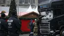 Petugas memeriksa kondisi truk yang menabrak Pasar Natal di Berlin, Jerman, Selasa (20/12). Akibat kejadian ini, dikabarkan 12 orang tewas dan 48 orang terluka. (REUTERS / Hannibal Hanschke)