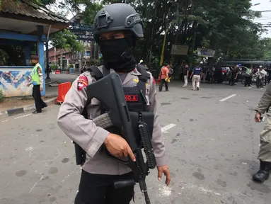 Petugas bersenjata berjaga di TKP terjadinya teror di Cikokol, Tangerang, Banten, Kamis (20/10). Dua anggota satlantas Polres Tangerang juga terkena tusukan dari pelaku yang diduga simpatisan ISIS. (Liputan6.com/Stringer)