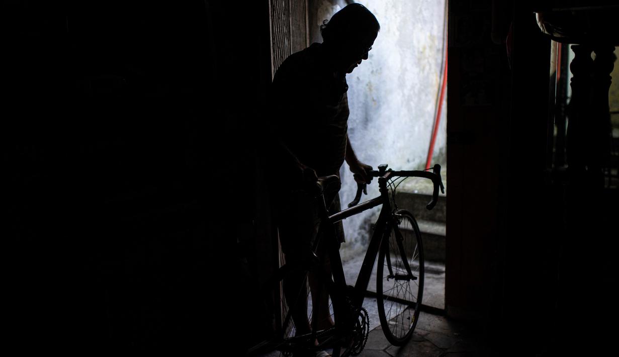 Raffaello Bianco, mekanik dan pecinta sepeda terlihat di pintu masuk bengkel mekaniknya di ruang bawah tanah apartemennya di Turin, Italia, 7 Juli 2020. Di antara banyak pesepeda amatir yang memintanya untuk memperbaiki sepeda, ada pengendara profesional seperti Fabio Fellini. (MARCO BERTORELLO/AFP)