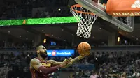 Bintang Cleveland Cavaliers, LeBron James, memasukkan bola pada laga melawan Milwaukee Bucks untuk membawa tim meraih kemenangan kedua pada musim reguler NBA 2017-2018. (AFP/Stacy Revere)