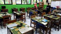Petugas mengecek kesiapan laptop dan ruang untuk Ujian Nasional Berbasis Komputer di SMP N 34 Pademangan, Jakarta Utara, Minggu (22/4). UNBK SMP 2018 akan berlangsung mulai besok Senin (23/4). (Liputan6.com/Johan Tallo)