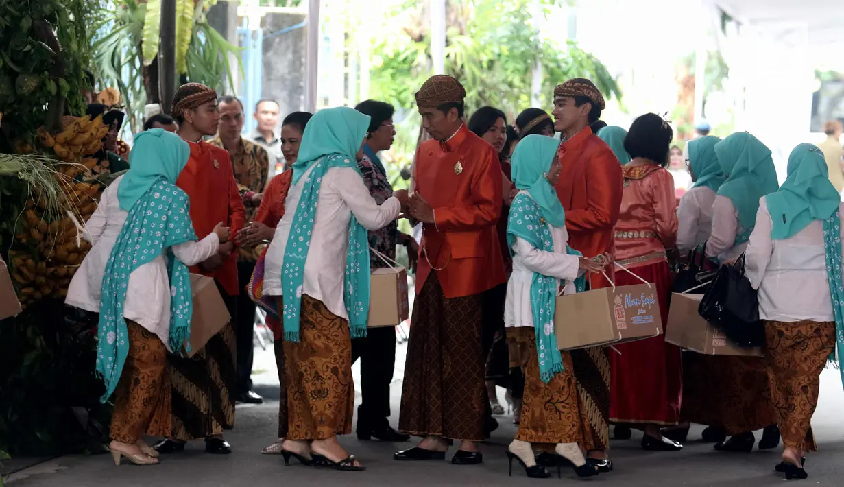 Presiden Joko Widodo (Jokowi) didampingi Ibu Negara, Iriana serta Gibran Rakabuming dan Kaesang Pangarep menyalami tamu yang pulang dari kediamannya di Jalan Kutai Utara, Solo usai prosesi siraman Kahiyang Ayu, Selasa (7/11). (Liputan6.com/Angga Yuniar)