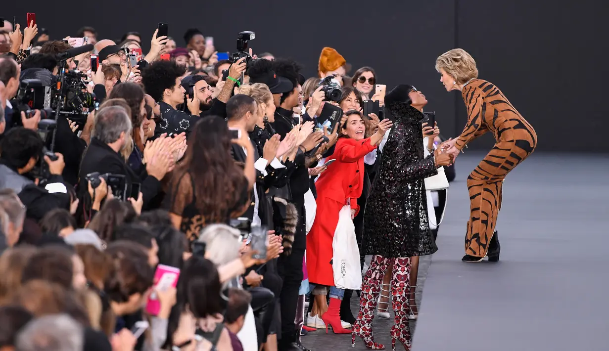 Aktris legendaris, Jane Fonda menyapa model Inggris, Naomi Campbell saat menampilkan koleksi L'Oreal selama Paris Fashion Week, Minggu (1/10). Jane sempat menghentikan langkahnya dan memeluk Naomi yang berada di kursi paling depan. (CHRISTOPHE SIMON/AFP)