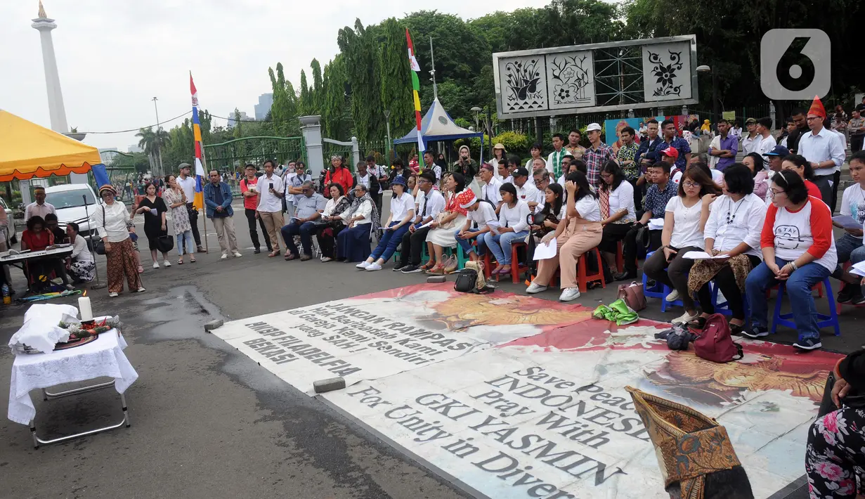 Jemaat dari Gereja Kristen Indonesia (GKI) Yasmin Bogor dan HKBP Filadelfia Bekasi melaksanakan misa Natal di Simpang Barat Laut Monas atau depan Istana Negara, Jakarta, Rabu (25/12/2019). Ini adalah misa natal kedelapan yang digelar jemaat dua gereja tersebut. (Liputan6.com/Helmi Fithriansyah)