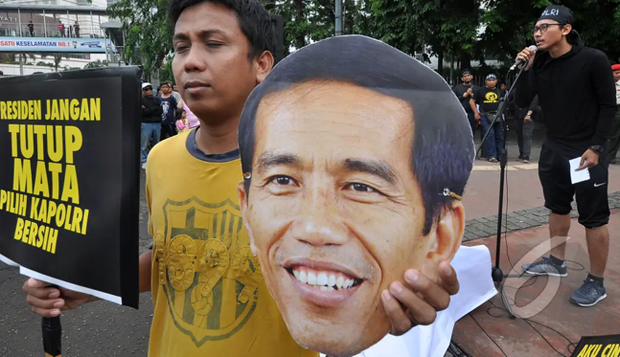 Massa dari Koalisi Untuk Reformasi Polri membawa topeng wajah Jokowi saat aksi di Car Free Day, Jakarta, Minggu (18/1/ 2015). (Liputan6.com/Miftahul Hayat)