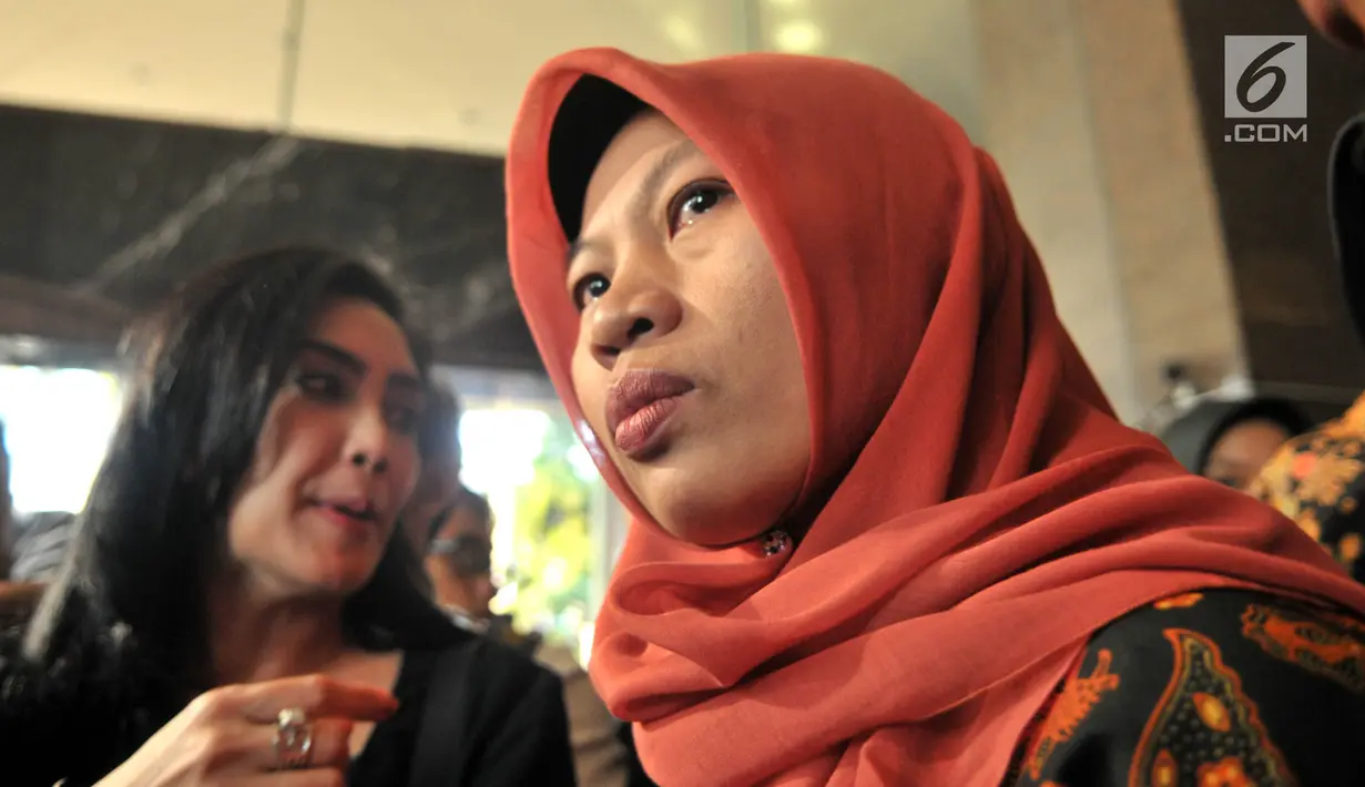 Terpidana kasus pelanggaran ITE Baiq Nuril Maknun (kanan) memberi keterangan saat tiba di Kantor Kemenkumham, Jakarta, Senin (8/7/2019). Guru honorer itu divonis 6 bulan penjara dan denda Rp 500 juta atas perekaman pelecehan seksual yang dialaminya. (merdeka.com/Iqbal Nugroho)