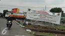 Pengendara motor melintasi spanduk sosialisasi penutupan perlintasan kereta sebidang di Stasiun Pasar Senen, Jakarta, (16/9). Uji coba penutupan perlintasan itu akan berlangsung selama satu bulan pada 1-31 Oktober 2016. (Liputan6.com/Gempur M Surya)