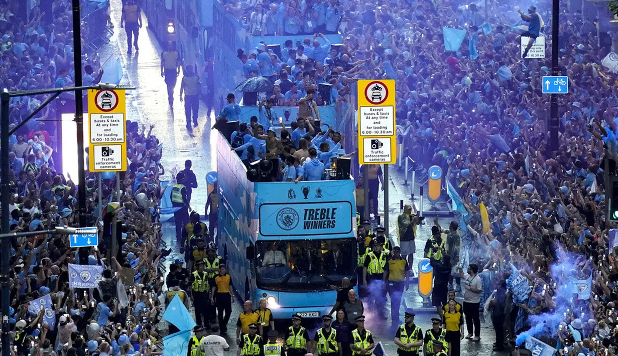 <p>Tim Manchester City berparade saat merayakan kemenangan Liga Inggris, Piala FA, dan Liga Champions di Manchester, Inggris, Senin (12/6/2023). (Danny Lawson/PA via AP)</p>