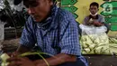 Pedagang menyelesaikan pembuatan kulit ketupat yang dijual di bawah kolong jembatan kawasan Pesanggrahan, Jakarta, Senin (10/5/2021). H-3 menjelang Hari Raya Idul Fitri 1442 H, penjualan kulit ketupat mulai marak yang dijual dengan harga Rp 8.000 per 10 buahnya. (Liputan6.com/Johan Tallo)