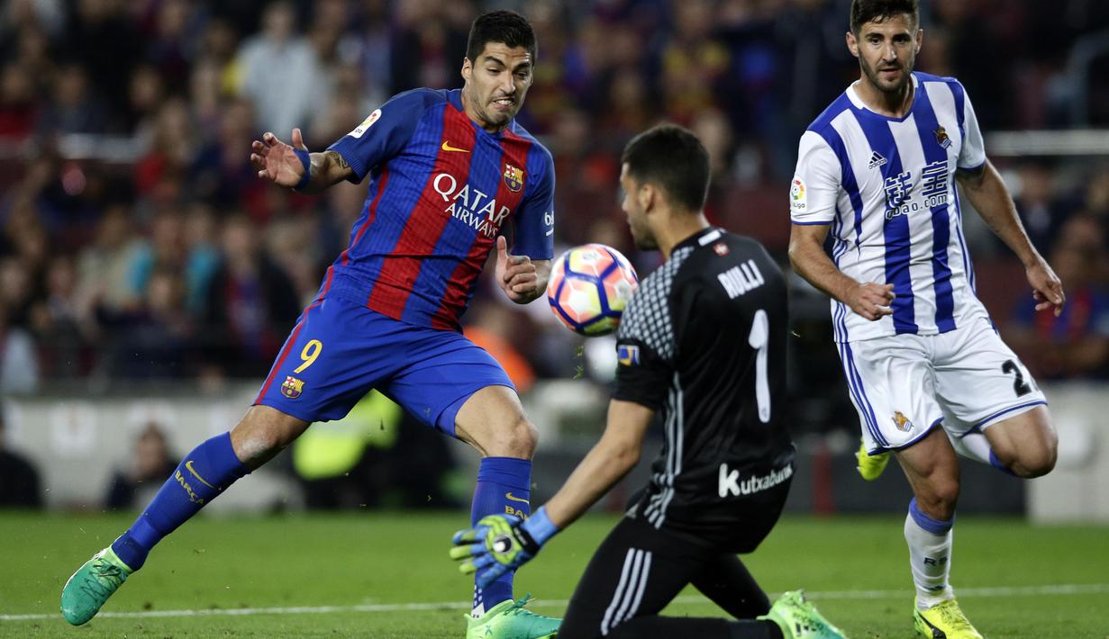 Aksi pemain Barcelona, Luis Suarez berhadapan dengan kiper Real Sociedad, Geronimo Rulli pada lanjutan La Liga di Camp Nou stadium in Barcelona, Spanyol, (15/4/2017). Barcelona menang 3-2.  (AP /Manu Fernandez)