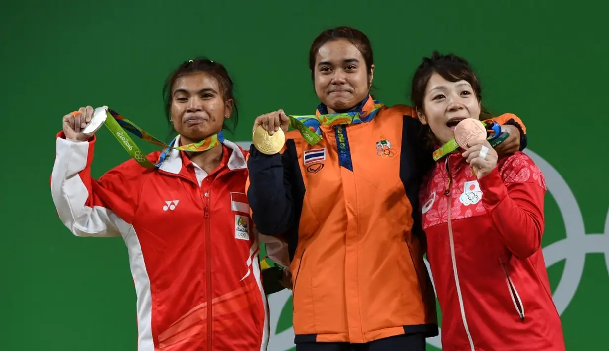 Sri Wahyuni (kiri) bersama peraih emas angkat besi kelas 48 kg dari Thailand, Sopita Tanasan (tengah), dan peraih perunggu, Hiromi Miyake, dari Jepang. (AFP/Goh Chai Hin)  