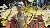 Hadiri kondangan, Krisdayanti terlihat simple dengan kebaya Kartini full bordir emas. Ia padukan dengan kain tenun merah yang kontras. [@krisdayantilemos]