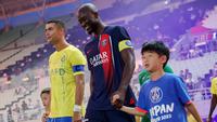 Pemain Al Nassr, Cristiano Ronaldo (kiri), dan pemain PSG, Danilo Pereira (tengah), berjalan menuju ke lapangan sebelum pertandingan uji coba antara Al Nassr melawan PSG yang berlangsung di Nagai Stadium, Osaka, Selasa (25/7/2023). (AFP/Paul Miller)
