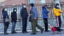 Seorang pria berjalan dengan seekor anjing melewati warga yang mengantre untuk tes COVID-19 di Distrik Fengtai, Beijing, China, Rabu (26/1/2022). Jelang Olimpiade Musim Dingin, Beijing melaporkan peningkatan lebih dari selusin kasus baru COVID-19 setiap harinya. (AP Photo/Andy Wong)