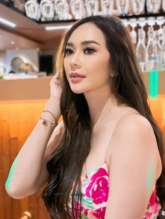 Aura Kasih tampil makeup flawless dengan lipstik nude dan blush on pink tipis. Rambut panjangnya dibiarkan terurai dengan gaya keriting bervolume dihiasi bunga mawar putih. [@aurakasih]