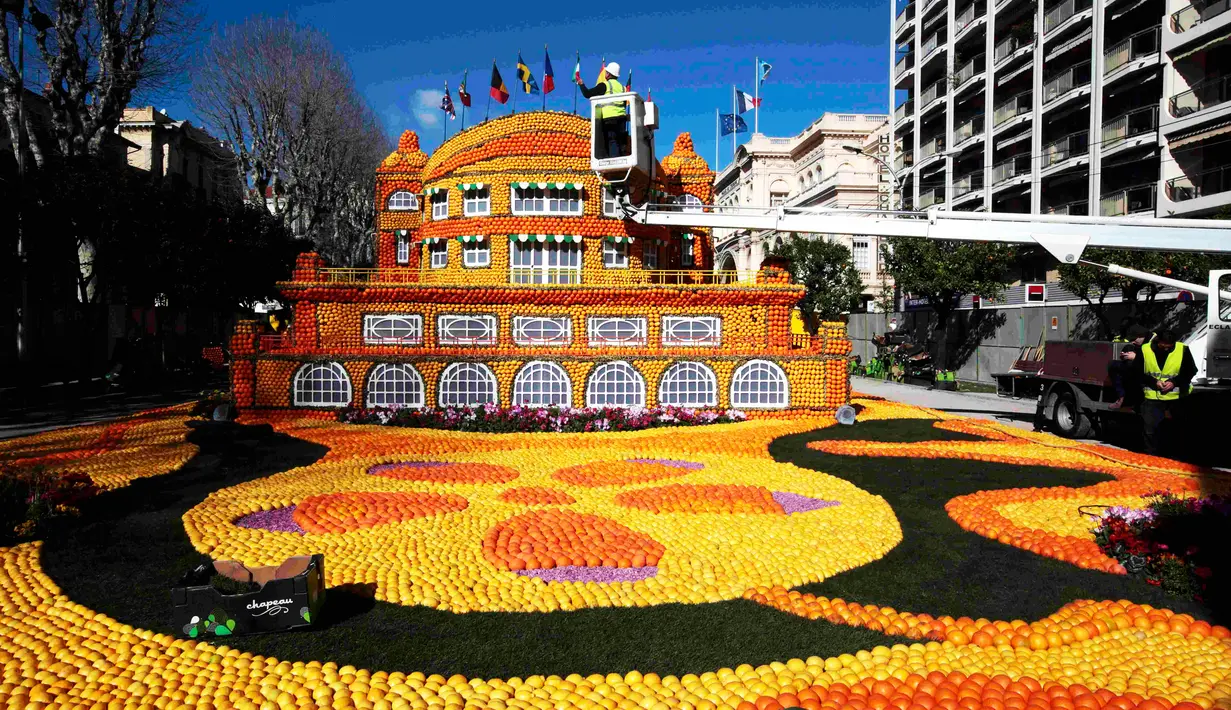 Pekerja merapikan sebuah replika bangunan di festival lemon, Menton , Prancis (10/2). Festival yang ke- 83 ini  yang bertema " Cinecitta ". (REUTERS/Eric Gaillard)