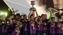 Kapten tim Barcelona, Sergio Busquet mengangkat trofi Supercopa de Espana 2023 disaksikan pemain lainnya setelah mengalahkan Real Madrid 3-1 dalam pertandingan Supercopa de Espana di King Fahd Stadium, Arab Saudi, Senin (16/1/2023) WIB. (AFP/Guiseppe Cacace)