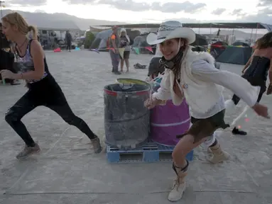 Pengunjung berlari saat mengikuti Carnival of Death dalam festival Burning Man 2015 di Gurun Black Rock, Nevada, (3/9/2015). Partisipan dari seluruh dunia hadiri festival seni unik ini selama sepekan. (REUTERS/Jim Urquhart)