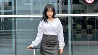 Fuji an memadukan midi skirt leather hitam dengan jaket crop top warna putih dan sneakersnya. [@fuji_an]