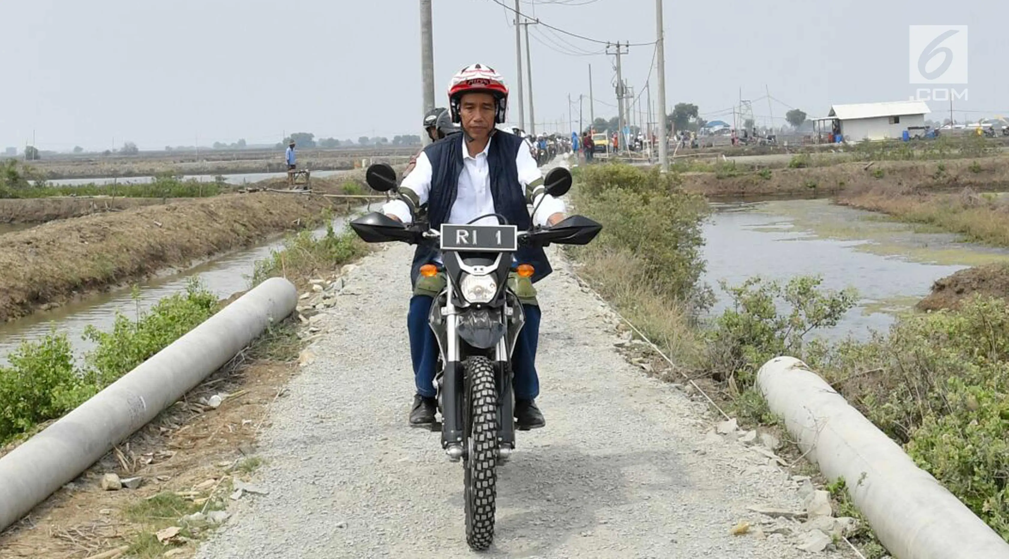 Presiden Joko Widodo mengendarai motor trail melintasi tambak udang di Muara Gembong, Bekasi (1/11). Jokowi menghadiri kegiatan Perhutanan Sosial untuk Pemerataan Ekonomi. (Liputan6.com/Biro Pers Kepresidenan/Agus Suparto)