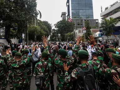 Prajurit TNI menghalau massa yang hendak menggelar demonstrasi 1812 di sekitar Istana Negara, Jakarta, Jumat (18/12/2020). Massa Aksi 1812 dihimbau oleh aparat yang bertugas agar membubarkan diri dan tidak berkerumun demi menghindari penyebaran COVID-19. (Liputan6.com/Johan Tallo)