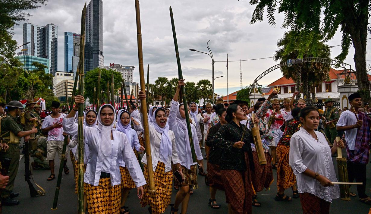Anggota Komunitas Roode Brug Soerabaia dan Reenactor Indonesia berpartisipasi dalam reka ulang Pertempuran Surabaya, Minggu 2 November 2025. Melalui drama teatrikal ini, komunitas sejarah Roode Brug Soerabaia dan Reenactor Indonesia mengajak seluruh elemen bangsa Indonesia, khususnya pemuda Surabaya, untuk mengenang semangat perjuangan arek-arek yang gugur mempertahankan kemerdekaan. (Juni KRISWANTO/AFP)
