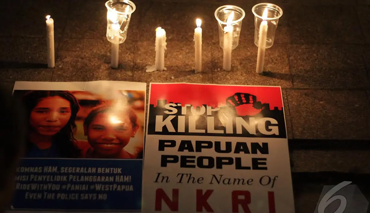 aktivis dari "Papua Itu Kita" melakukan aksi bakar lilin meminta Presiden Jokowi untuk bersuara tentang penembakan dan bentrokan tersebut, Jakarta, Kamis (18/12/2014). (Liputan6.com/Faizal Fanani)