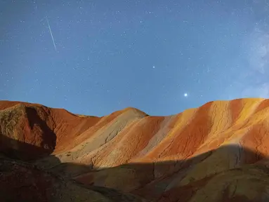 Foto eksposur panjang yang diabadikan pada 13 Agustus 2020 ini menunjukkan hujan meteor Perseid di Taman Geologi Nasional Danxia Zhangye di Zhangye, Provinsi Gansu, China barat laut. (Xinhua/Zhong Xiaoliang)