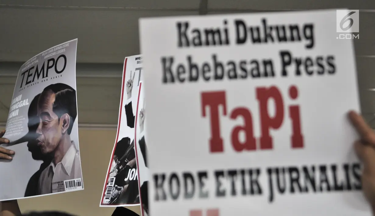 Relawan Jokowi Mania mengangkat poster bergambar sampul Majalah Tempo saat mendatangi Gedung Dewan Pers, Jakarta, Senin (16/9/2019). Kedatangan relawan tersebut untuk melaporkan Majalah Tempo edisi 16-22 September 2019 dengan cover "Janji Tinggal Janji" ke Dewan Pers. (merdeka.com/Iqbal S. Nugroho)