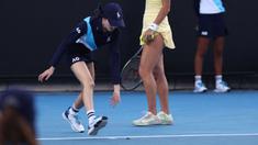 Seorang ball girl berusaha menangkap seekor serangga yang memasuki lapangan ketika laga Australia Open 2024 antara petenis Inggris, Emma Raducanu melawan petenis Amerika Serikat di Melbourne Park, Melbourne, Australia, Selasa (16/01/2024). (AFP/David Gray)