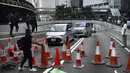 Demonstran menempatkan kerucut lalu lintas untuk menghalangi jalan selama protes di distrik keuangan di Hong Kong (14/11/2019). Warga Hong Kong mengalami hari keempat kemacetan lalu lintas dan gangguan angkutan massal ketika pengunjuk rasa menutup beberapa jalan utama. (AP Photo/Vincent Yu)