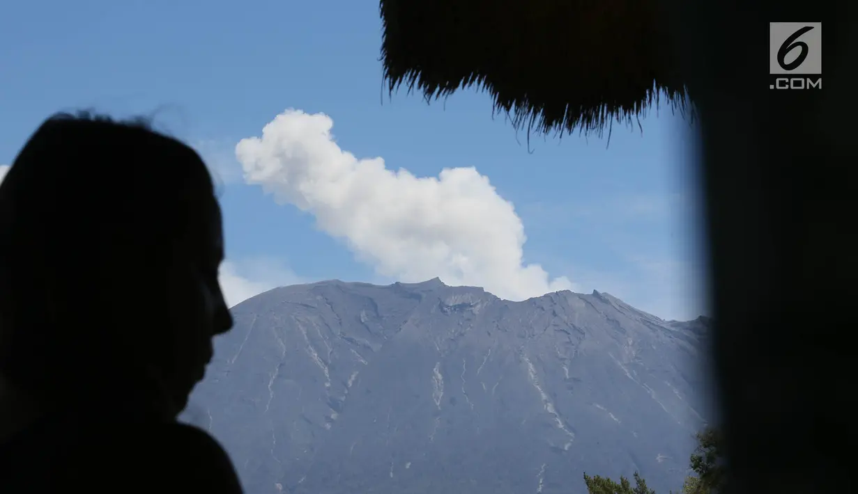 Gunung Agung erupsi mengembuskan asap bercampur abu vulkanik terlihat dari kawasan Sidemen, Karangasem, Bali, Jumat (8/12). Erupsi magmatik tersebut berembus hingga ketinggian 2.100 meter di atas puncak kawah. (Liputan6.com/Immanuel Antonius)