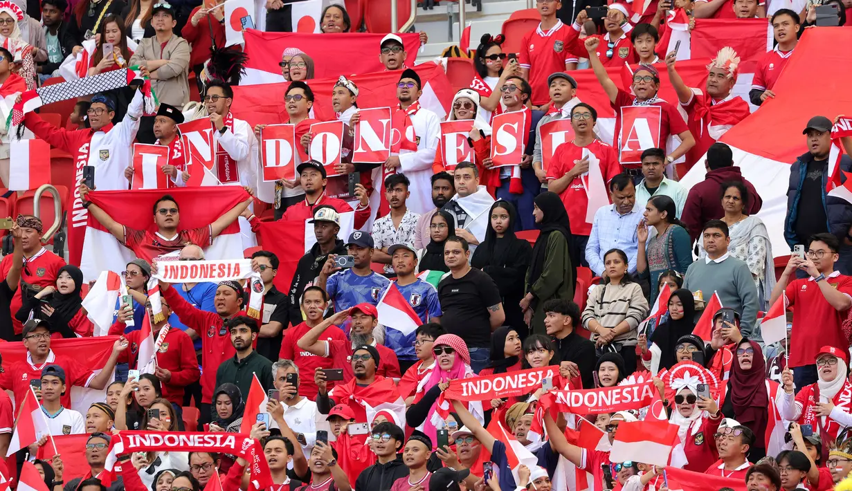 Para pendukung Indonesia memberi dukungan kepada Timnas Indonesia saat menghadapi Jepang pada laga ketiga Grup D Piala Asia 2024 di Al-Thumama Stadium, Doha, Qatar, Rabu (24/1/2024) malam WIB. (AFP/Giuseppe Cacace)
