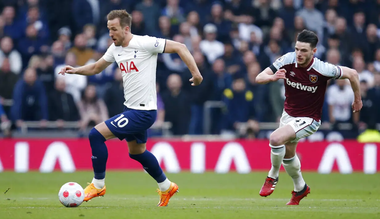 Pemain Tottenham Hotspur Harry Kane (kiri) berebut bola dengan pemain West Ham United Declan Rice pada pertandingan sepak bola Liga Inggris di Tottenham Hotspur Stadium, London, Inggris, Minggu (20/3/2022). Tottenham Hotspur menang 3-1. (AP Photo/David Cliff)