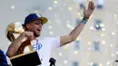 Pemain Guard Golden State Warriors, Stephen Curry memeluk tropi Larry O'Brien saat menggelar parade Warriors 2018 usai menjuarai NBA 2018 di pusat kota Oakland, California, Amerika Serikat, (12/6). (AP Photo/Marcio Jose Sanchez)