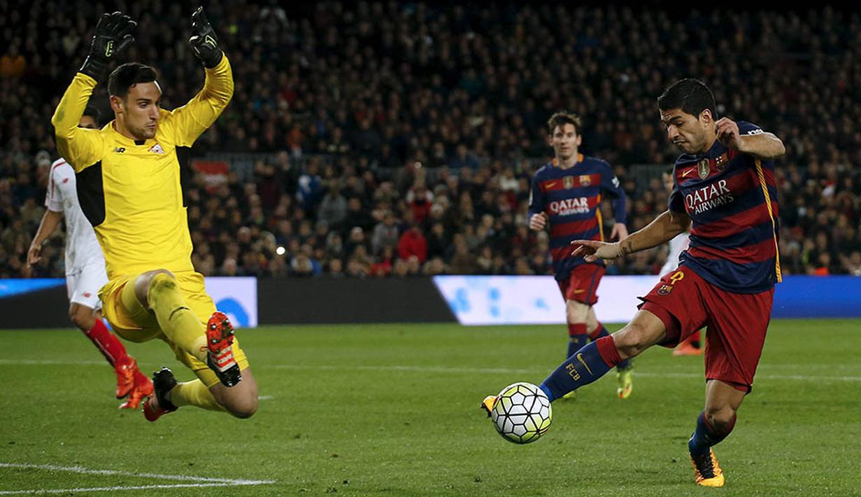 4. Striker Barcelona, Luis Suarez, berupa mengecoh kiper Sevilla, Sergio Rico, pada laga La Liga Spanyol di Stadion Camp Nou, Minggu (28/2/2016). Bercelona berhasil menang 2-1 atas Sevilla. (Reuters/Albert Gea)