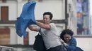 Dua orang memegang payung sambil berjalan menghindari angin kencang yang disebabkan topan Dujuan di Taipei, Taiwan, Senin (28/9). Ribuan orang diungsikan untuk menghadapi topan raksasa Dujuan yang diprediksikan akan menyerang Taiwan.(REUTERS/Pichi Chuang)