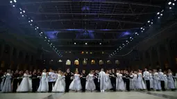 Para siswa sekolah militer bersiap untuk menari saat pesta tahunan Cadet Ball di Moskow, Rusia, Selasa (17/12/2019). Dalam acara ini para peserta mengenakan seragam dan gaun sambil menari tradisional dengan alunan musik klasik. (AP Photo/Alexander Zemlianichenko)
