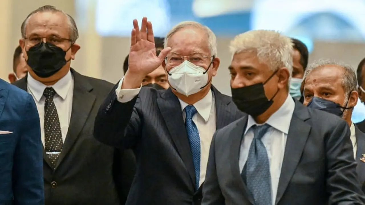 Mantan Perdana Menteri Malaysia Najib Razak melambaikan tangan saat tiba di pengadilan federal di Putrajaya pada 15 Agustus 2022. (Foto: AFP/Mohd Rasfan)