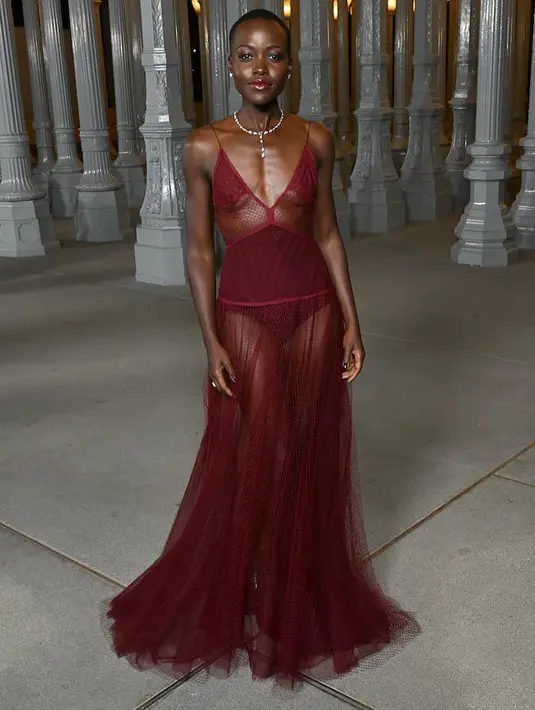 Lupita Nyong'o memesona tampil berani dibalut dress semi-transparan bernuansa wine dari Gucci. [Foto: Instagram/thisisannasfashion]