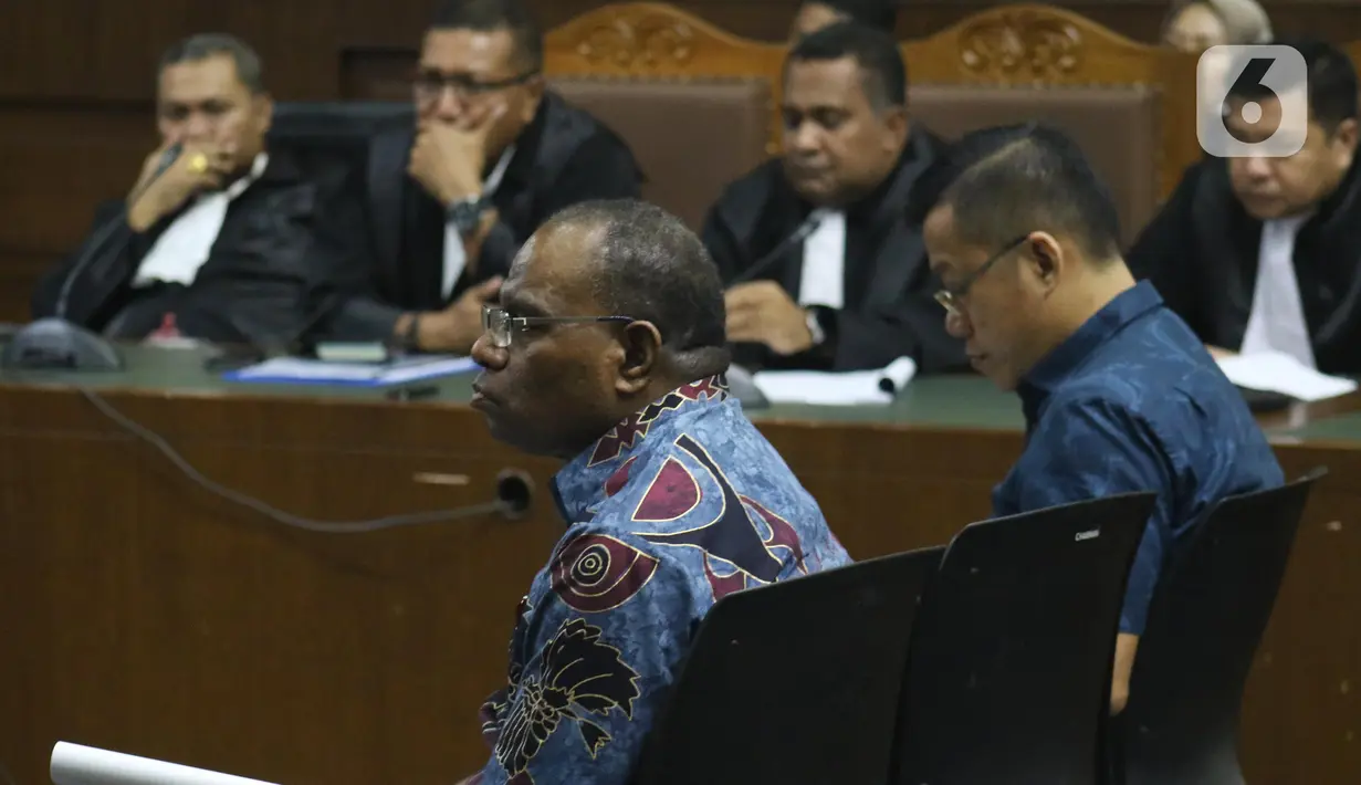 Mantan Kadis PU Papua, Mikael Kambuaya (kiri) dan Komisaris PT MBM, David Manibui saat sidang dakwaan di Pengadilan Tipikor Jakarta, Rabu (20/11/2019). Keduanya didakwa merugikan negara sekitar Rp40,93 miliar dalam pekerjaan peningkatan jalan Kemiri-Depapre TA 2015. (Liputan6.com/Helmi Fithriansyah)