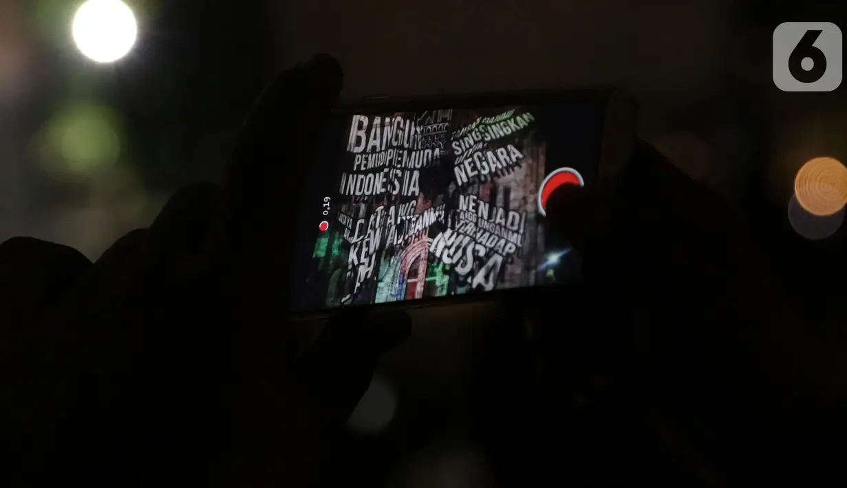 Umat kristiani merekam pemutaran video mapping di Gereja Katedral yang bercerita sejarah Kongres Pemuda II , Jakarta, Minggu (27/12/2019). Pemutaran video mapping ini untuk memperingati Hari Sumpah Pemuda ke-91 dan berlangsung hingga 28 Oktober. (Liputan6.com/Helmi Fithriansyah)