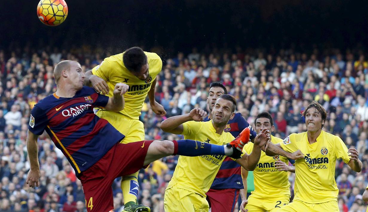 Pemain Barcelona Jeremy Mathieu (kiri) berebut bola dengan para pemain Villarreal  pada lanjutan La Liga Spanyol di Stadion Camp Nou, Barcelona, Spanyol, MInggu (8/11/2015). (REUTERS/Albert Gea)